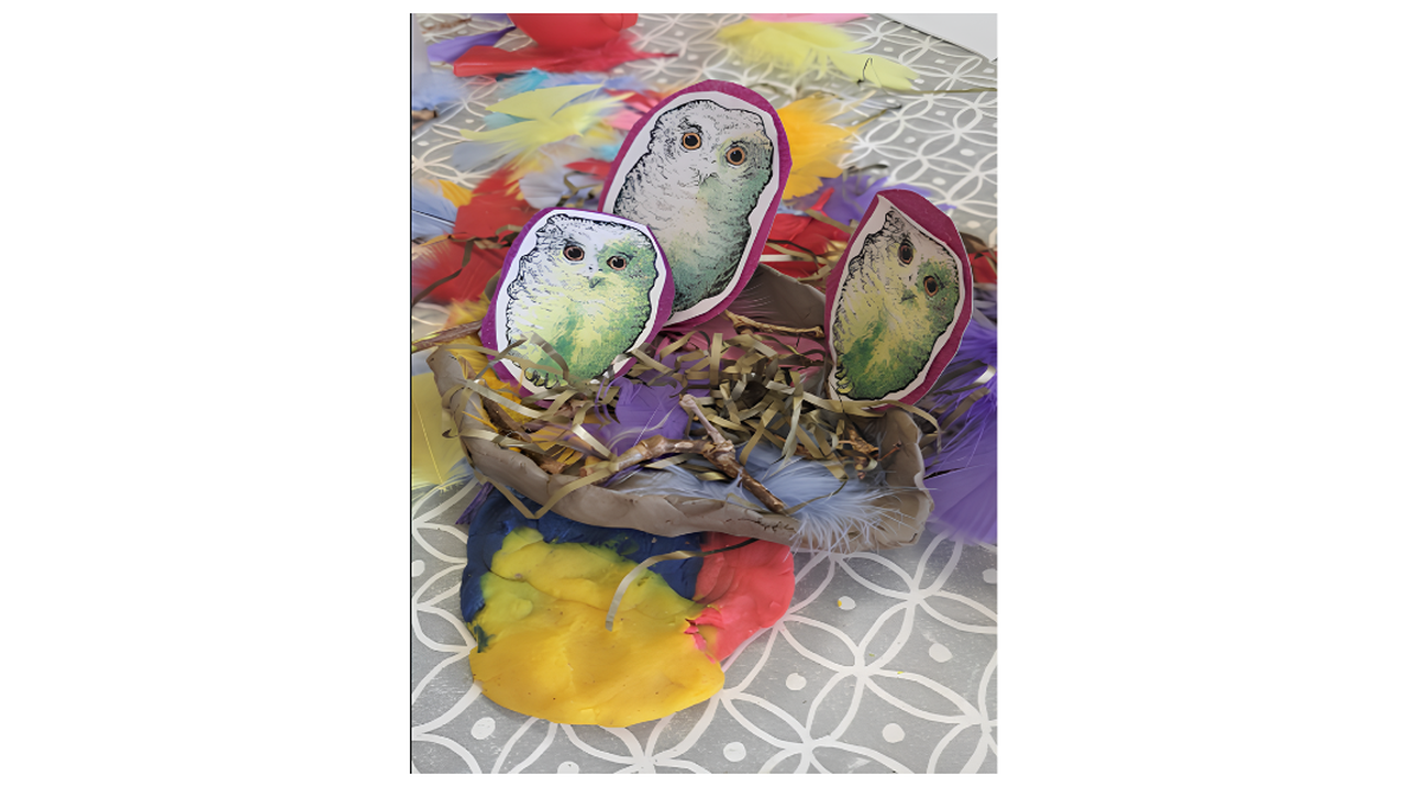 Crafted birds with colorful feathers in a paper nest on a patterned surface.